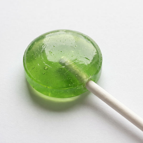 Green apple flavored lollipop on a white stick